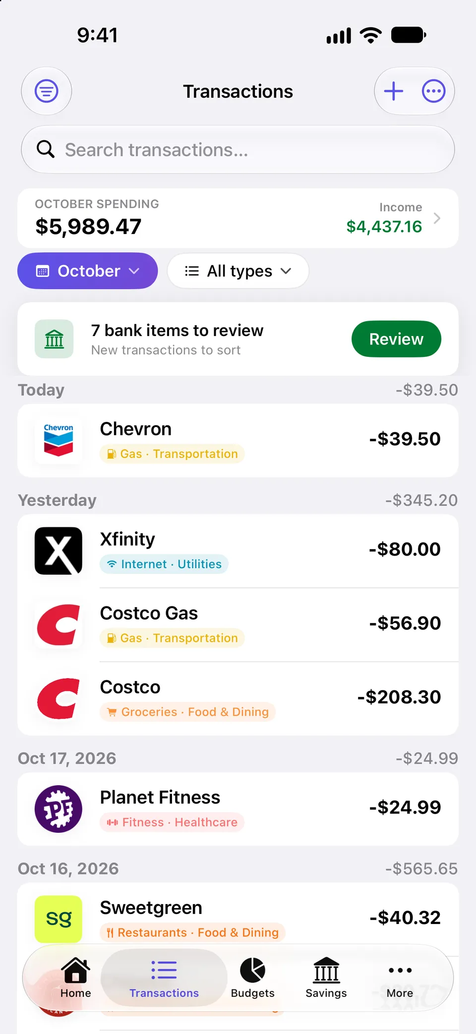 Transactions feed with October spending and income totals, a banner for 7 bank items waiting for review, and transactions grouped by day, each with a merchant logo and a colored category tag.